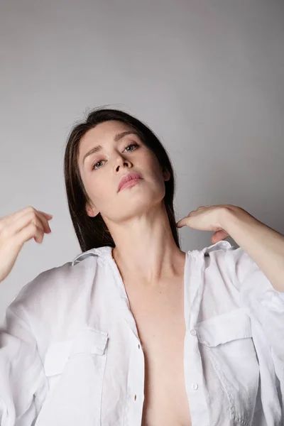 Mujer joven, lleva camisa blanca, posando en el estudio. —  Fotos de Stock