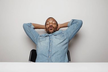 Stüdyoda poz veren ve dalga geçen genç bir zenci. İzole edilmiş.