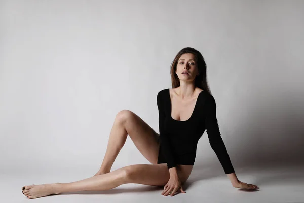 Fitness kvinna, bär svart kropp, poserar i studion. Isolerad. — Stockfoto