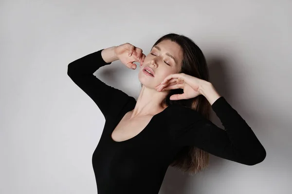 Jovem mulher fitness, usa corpo negro, posando com os olhos fechados no estúdio. — Fotografia de Stock