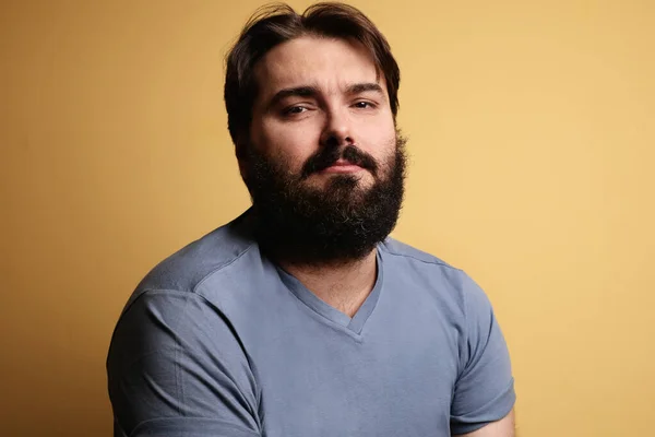 Hoofdfoto van een grote man met een baard, poserend over een gele achtergrond. geïsoleerd. — Stockfoto