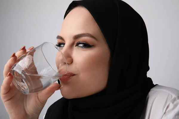 穿黑色头巾喝水的穆斯林妇女的剪影. — 图库照片