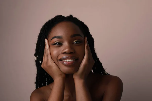 Uma jovem negra feliz posando no estúdio. Retrato de close-up isolado. — Fotografia de Stock