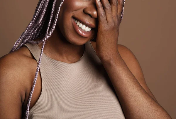 Close-up portret van een vrolijke zwarte vrouw. Geïsoleerd op beige achtergrond. — Stockfoto