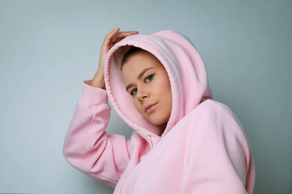 Close-up of young woman posing on white background, with the hood over the heads — Stok Foto
