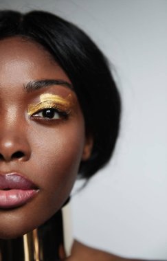 Stüdyoda poz veren, doğal ciltli siyahi bir kadının vesikalık fotoğrafı..