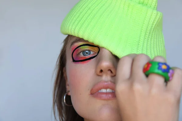 Portrait de jeune femme avec maquillage créatif, porte un bonnet tricoté brillant. — Photo