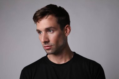 Beyaz arka planda izole edilmiş yakışıklı, düşünceli bir adamın portresi..