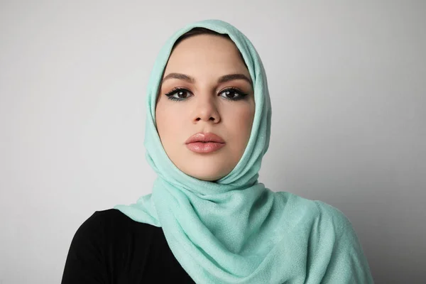 Portrait d'une jeune femme arabe portant un hijab coloré, isolée sur un mur blanc. — Photo