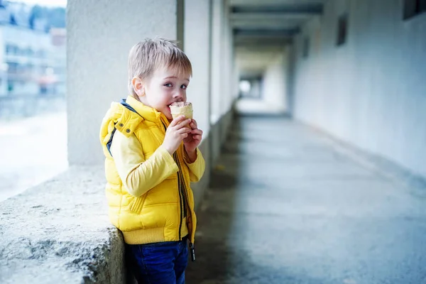 Мальчик Желтке Ест Мороженое Фоне Длинного Серого Коридора — стоковое фото