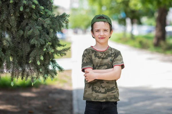 Cute Boy Shirt Military Print Cap Stands Background Green Spruce — Stock Photo, Image