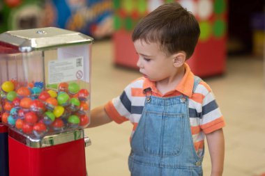 Küçük sarışın çocuk markette oyun oynuyor.