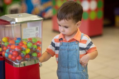 Küçük sarışın çocuk markette oyun oynuyor.