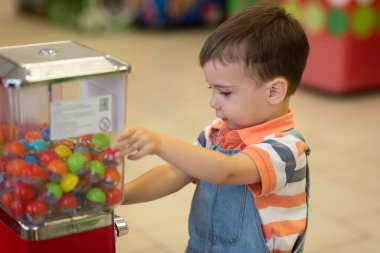 Küçük sarışın çocuk markette oyun oynuyor.