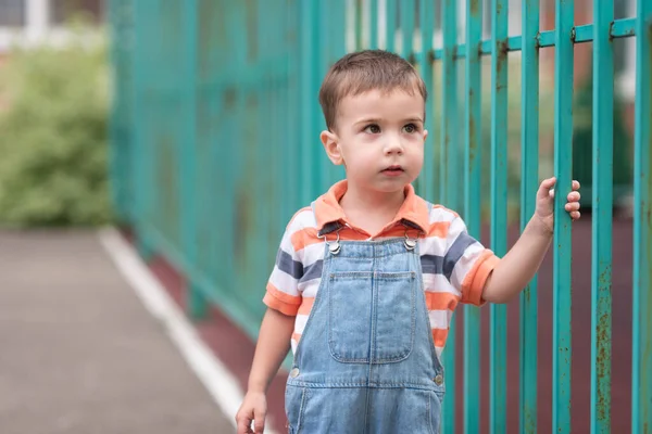 Ein Junge Auf Dem Spielplatz Ein Hoher Grüner Zaun Ein — Stockfoto