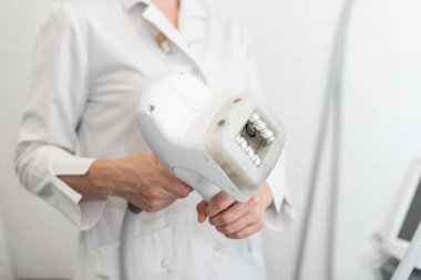 Uzman bir doktorun elinde yakın plan rf-lift aparatı. Kozmetoloji kavramı