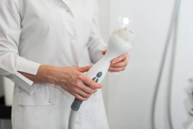 Uzman bir doktorun elinde yakın plan rf-lift aparatı. Kozmetoloji kavramı