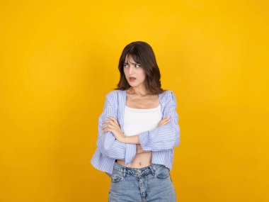 Üzgün bir kadın, 20 'li yaşlarda üzgün bir kadın. Sarı arka plan stüdyo fotoğrafında tek başına duruyor..