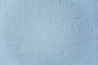 Pürüzsüz, soluk mavi tonda, ince desenli duvar yüzeyi.