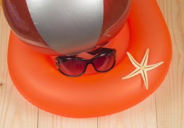 Yüzük, top, güneş gözlüğü ve denizyıldızı ahşap arka plan üzerinde yüzme