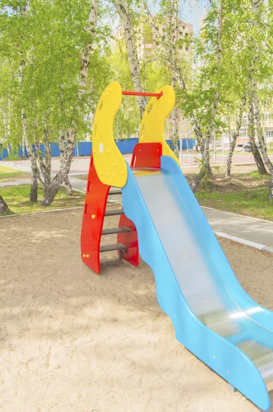 Corrediça de crianças coloridas no parque infantil no parque — Fotografia de Stock