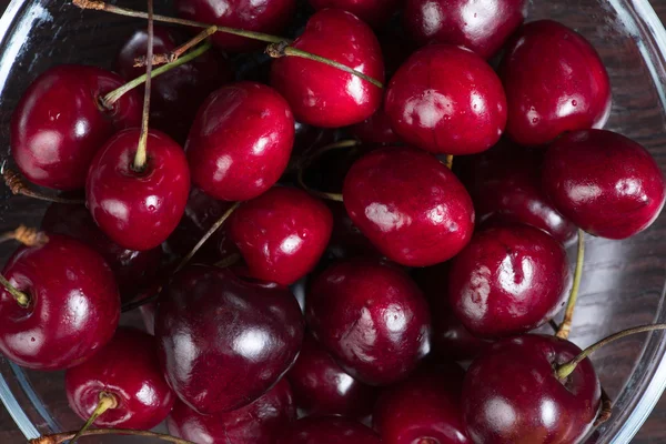 Fresh sweet cherries in bowl on dark background, top view — Stock Photo, Image
