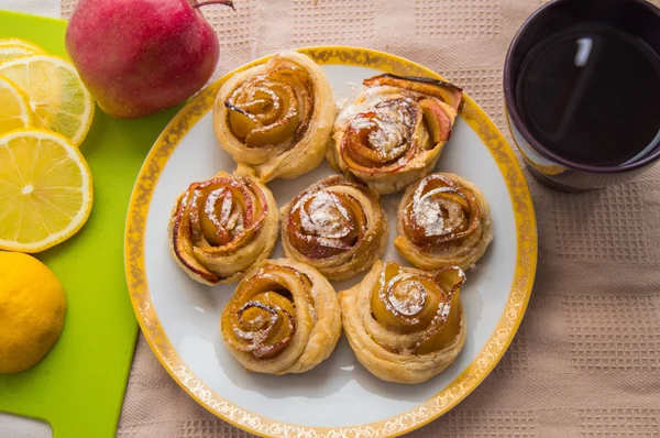 Apple cider cinnamon rolls, with icing sugar. Cup of tea — Stock Photo, Image