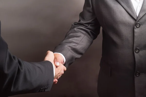 灰色の背景に 2 つの成功したビジネスマンの握手 — ストック写真
