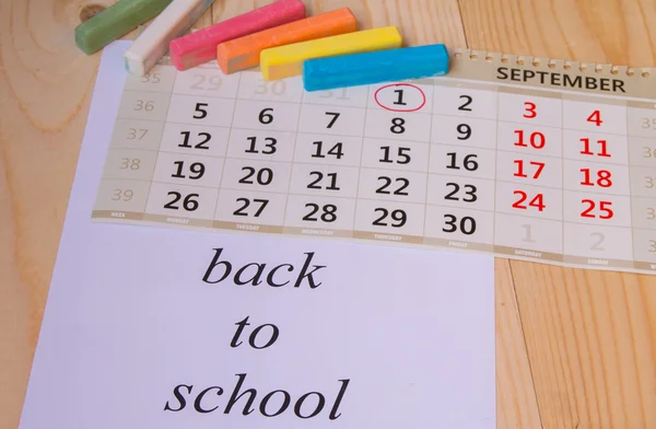 Retour à l'école, calendrier, craie colorée sur fond bois — Photo