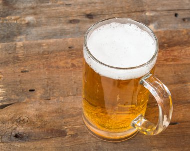 Light bira bir karanlık vintage ahşap kurullarında köpük bardak