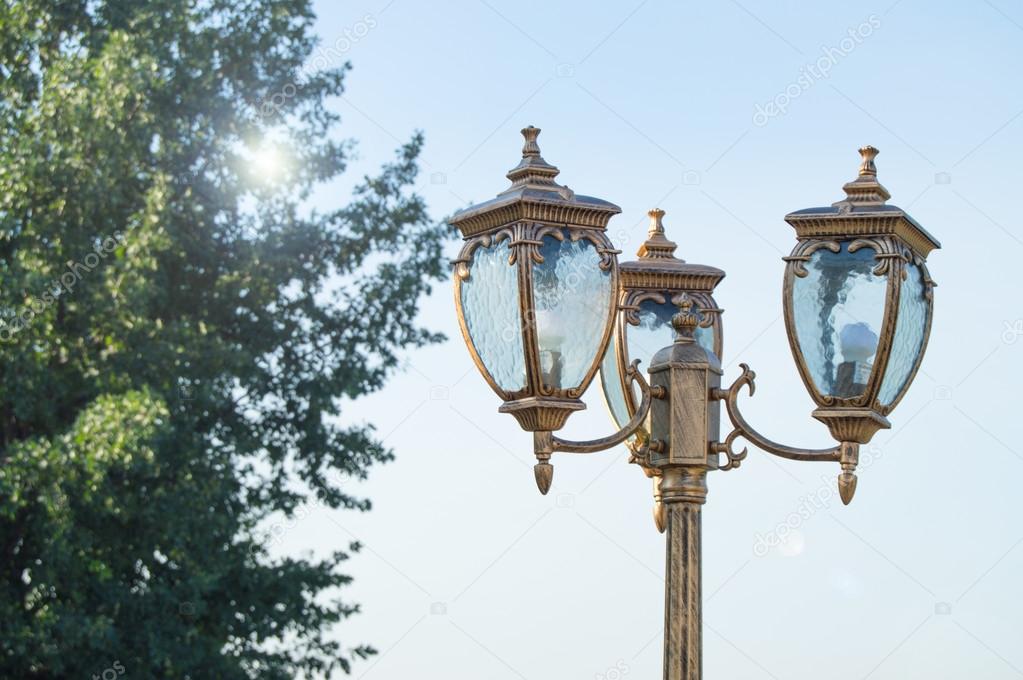 Closeup of a lantern in the Park on the sky background and sun glare