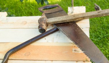 Yapı aletleri çekiç, balta, demir testeresi çerçeve, bahçedeki ışık panolarına uzanır..