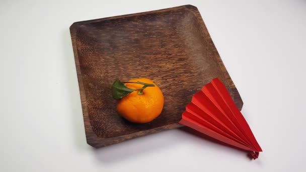 Una Mano Coloca Abanicos Papel Origami Rojo Plato Mandarinas Madera — Vídeo de stock