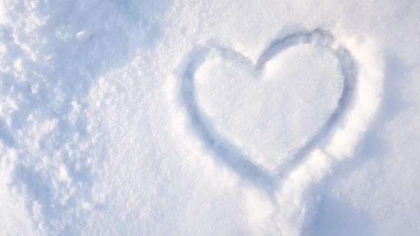 4Kビデオ、公園内の雪の上に描かれた心。バレンタインデー市内の冬休みスローモーションカメラ — ストック動画