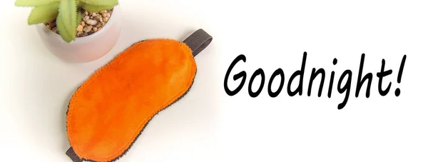 Visão superior de uma máscara de sono laranja e uma flor, uma atitude positiva para dormir, um banner com o texto Boa Noite — Fotografia de Stock