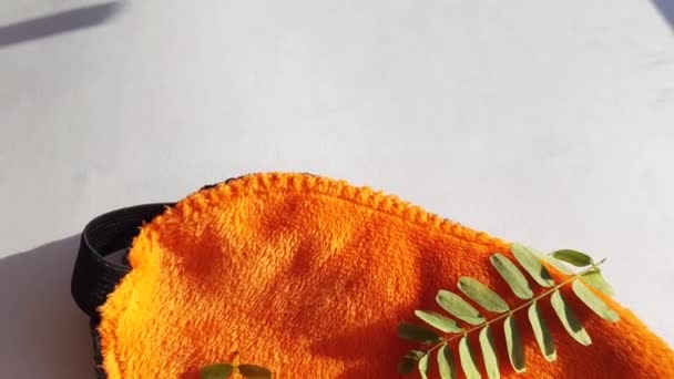 Kamera Pohyb Přes Měkkou Oranžovou Oční Masku Ležící Ráno Bílém — Stock video