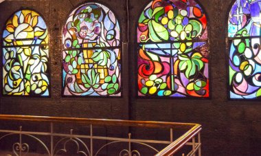 Arka arkaya lekeli cam pencereler ve merdiven, çok renkli cam sanatı pencereleri olan antika bir oda..