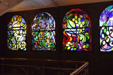 Arka arkaya lekeli cam pencereler ve merdiven, çok renkli cam sanatı pencereleri olan antika bir oda..