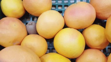Yavaş çekim kamerası, bir süpermarketteki olgun greyfurtların yakın çekim videosu, 4K video.