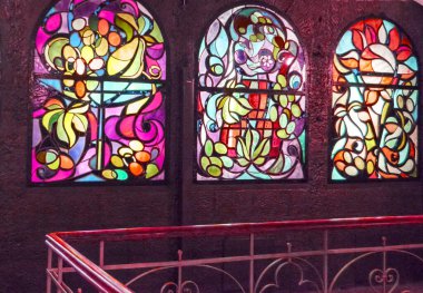 Arka arkaya lekeli cam pencereler ve merdiven, çok renkli cam sanatı pencereleri olan antika bir oda..