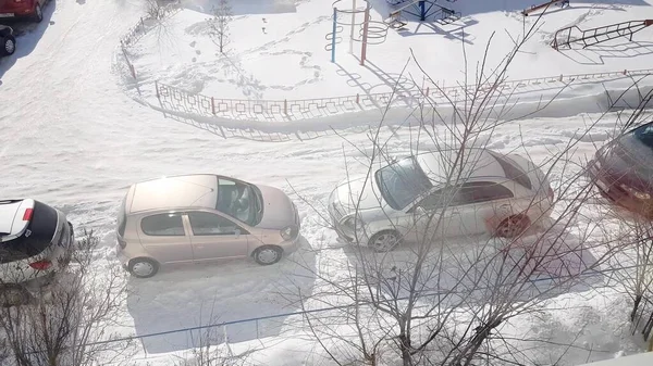駐車場の多階建ての建物の窓からの眺め道に駐車し晴れた冬の日 — ストック写真