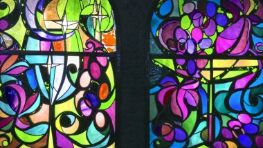 Çiçek ve meyve süslemeleri ile çok renkli camların soyut arka planına sahip iki dikey vitray pencere..