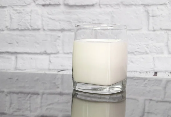 Leche Una Taza Vidrio Transparente Sobre Mesa Reflejo Sobre Fondo —  Fotos de Stock