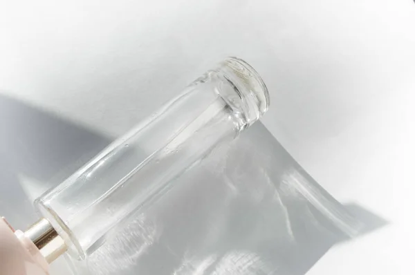Puste Szkło Przezroczyste Butelka Perfum Odcieniami Słońca Białym Tle Załamanie — Zdjęcie stockowe