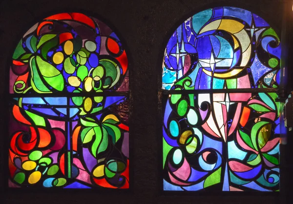 花や果物の装飾が施された多色ガラスの抽象的な背景を持つ2つの垂直ステンドグラスの窓 — ストック写真
