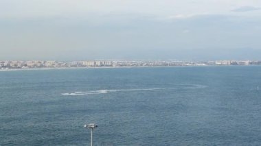 Deniz manzaralı video. Sürat tekneleri ve beyaz renkli yelkenliler, İspanya kıyılarında, Valencia kıyılarında, mavi sularda hızla ilerler..