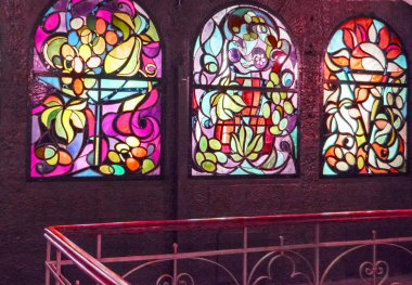 Arka arkaya lekeli cam pencereler ve merdiven, çok renkli cam sanatı pencereleri olan antika bir oda..