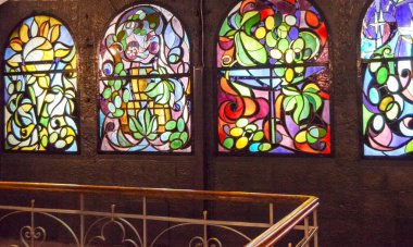 Arka arkaya lekeli cam pencereler ve merdiven, çok renkli cam sanatı pencereleri olan antika bir oda..