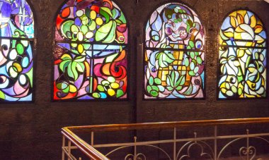 Arka arkaya lekeli cam pencereler ve merdiven, çok renkli cam sanatı pencereleri olan antika bir oda..