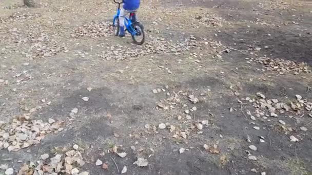 고무장화를 소년이 위에서 자전거타는 배우고 모습을 돌아보라 자녀의 비디오 — 비디오